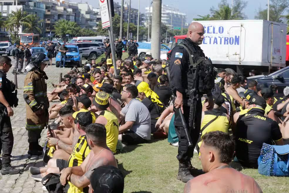 Torcedores do Peñarol incendeiam ônibus e moto, depredam quiosques e enfrentam a polícia na praia do Recreio, no Rio de Janeiro